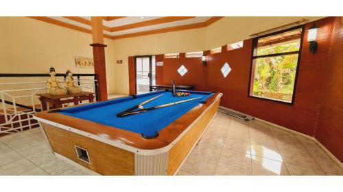 a pool table in the middle of a room at PLUM Hotel Palereman Batu in Batu
