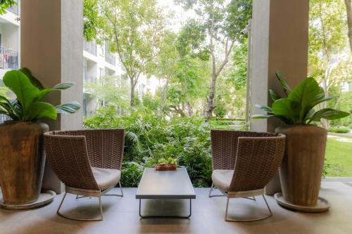 a patio with three chairs and a table and plants at Hua Hin La Casita Beautiful Two Bedroom Condo With Great Views in Hua Hin