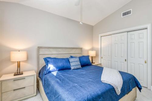 a bedroom with a blue bed and two lamps at Luxury 4-BR-BBQ-waterview-screened lanai-wood floors 211 in Saint Augustine