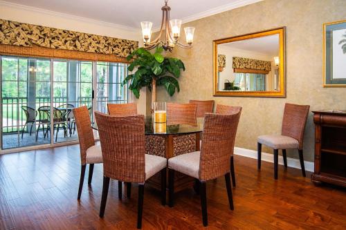 a dining room with a table and chairs and a mirror at 3BR 3BA with Golf Course View from screened lanai 1226 in Sampson