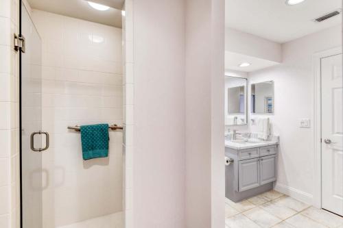 a white bathroom with a shower and a sink at Spacious 3 BR plus SS in Den & screened lanai waterside in Sampson