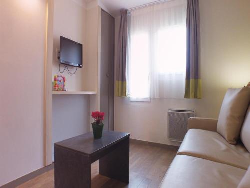 un salon avec un canapé, une table et une fenêtre dans l'établissement Gîte in Normandy near Sandy Beach, à Port-Bail-sur-Mer