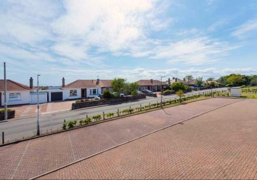 a street in a residential neighborhood with a fence at Coastal Haven- stunning home in Crail in Crail