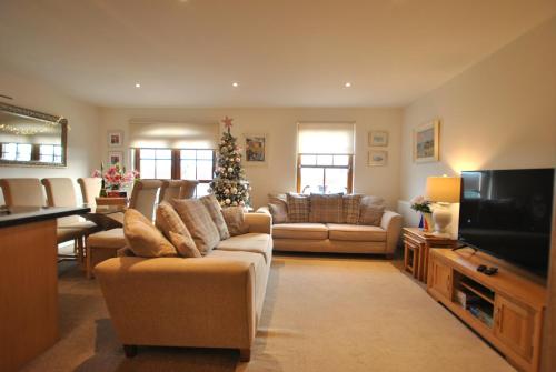 a living room with couches and a christmas tree at Coastal Haven- stunning home in Crail in Crail
