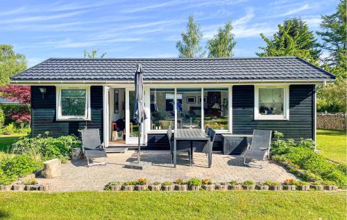 una casa blu con tavolo, sedie e ombrellone di 2 Bedroom Cozy Home In Frederiksværk a Frederiksværk