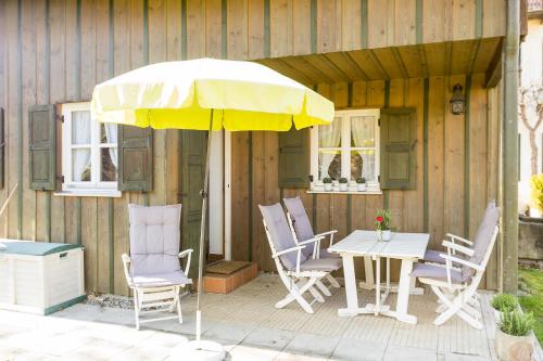 a table and chairs and an umbrella on a patio at Ferienhaus Alp Chalet in Kochel