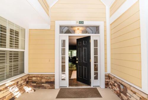 an open door to a house with yellow siding at 4 bedroom - large screened lanai and views 414-4 in Sampson
