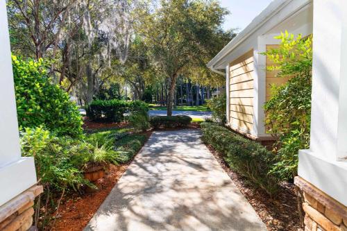 a walkway in front of a house with trees at 4 bedroom - large screened lanai and views 414-4 in Sampson