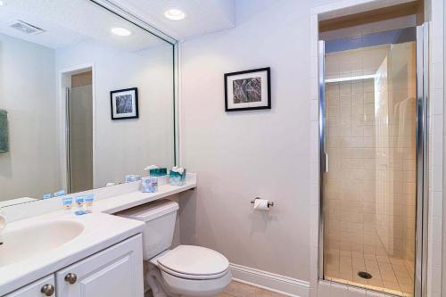 a bathroom with a shower and a toilet and a sink at 4 bedroom - large screened lanai and views 414-4 in Sampson