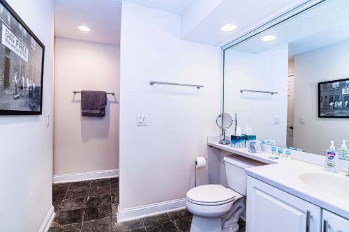 a bathroom with a toilet and a sink and a mirror at 4 bedroom - large screened lanai and views 414-4 in Sampson