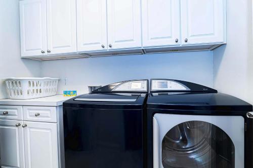 a kitchen with a black and white washing machine at 4 bedroom - large screened lanai and views 414-4 in Sampson