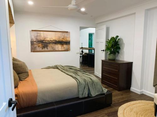 a bedroom with a bed and a painting on the wall at The Pool House Carrara in Gold Coast
