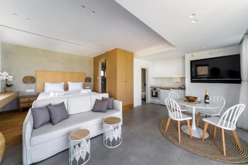 a bedroom with a white bed and a table and chairs at Villa Kamelia with pool in Gournes