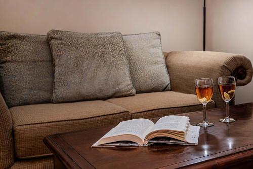 a coffee table with a book and two glasses of wine at 2 BR Secluded patio with courtyard 5107P2 in Saint Augustine