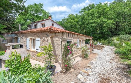 a small stone house with flowers in a garden at Amazing Home In Le Val in Le Val