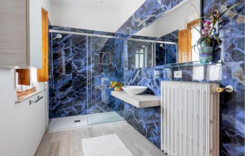a blue tiled bathroom with a shower and a sink at Poggioalvento in Lazzeretto