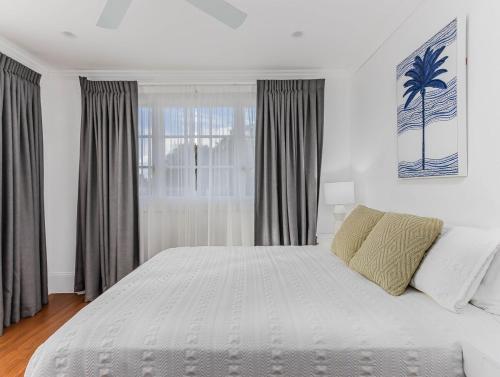 a bedroom with a large white bed and a window at Hamptons White House in Murwillumbah