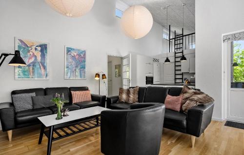 a living room with a black couch and a table at Cozy Home In Ringkøbing With Sauna in Ringkøbing