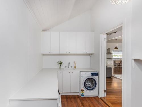 a white kitchen with a washing machine in it at Hamptons White House in Murwillumbah