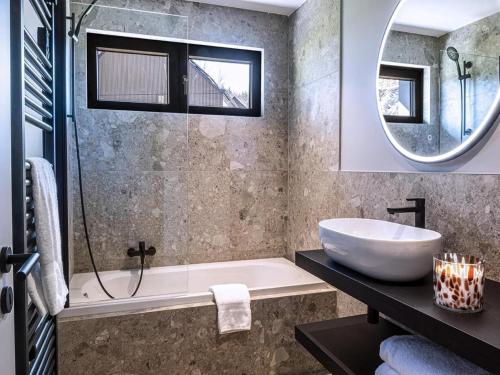 a bathroom with a tub and a sink and a mirror at Villa in Belgium with Private Terrace in La Roche-en-Ardenne
