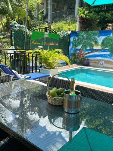 una mesa con una cesta de fruta junto a la piscina en Marvette Ocean view villa, en Whitehouse