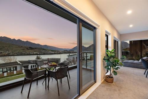 a patio with a table and chairs on a balcony at St Matthews Views Cecil in Queenstown