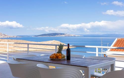 a table with a bottle of wine and fruit on a balcony at 2 Bedroom Lovely Apartment In Lukovo in Lukovo