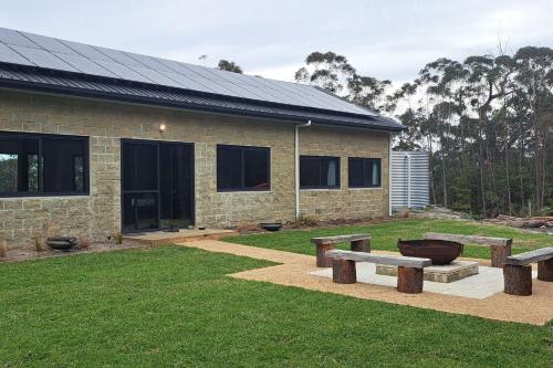 a brick building with benches in front of it at Red Rocks Mountain Retreat, Browns Mountain, Kangaroo Valley in Kangaroo Valley