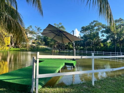 a bench with an umbrella in the middle of a river at Casa in Ahuashiyacu