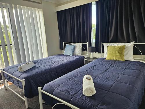 two beds sitting next to each other in a bedroom at Fairways Golf & Beach Retreat Bribie Island in Woorim