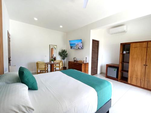 a bedroom with a large white bed and a table at Punta Colibrí in Brisas de Zicatela