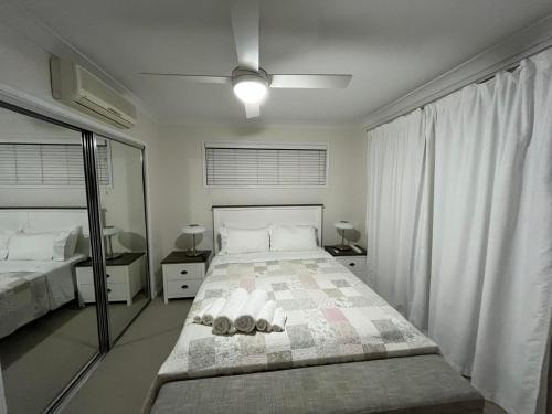 a white bedroom with a large bed and a window at Happy Haven at Eight Mile in Brisbane