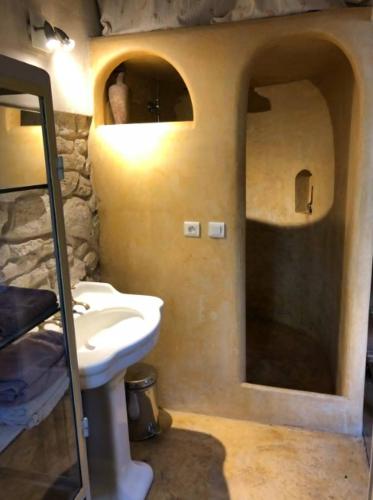 une salle de bain avec un lavabo et un mur en pierre dans l'établissement Bungalow Champigny sur Marne, France, à Champigny-sur-Marne