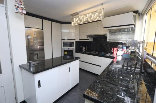 a kitchen with white cabinets and black counter tops at Brand new apartment 4 blocks from Plaza Armas Arequipa in Arequipa