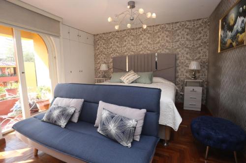 a bedroom with a bed and a blue couch at Brand new apartment 4 blocks from Plaza Armas Arequipa in Arequipa