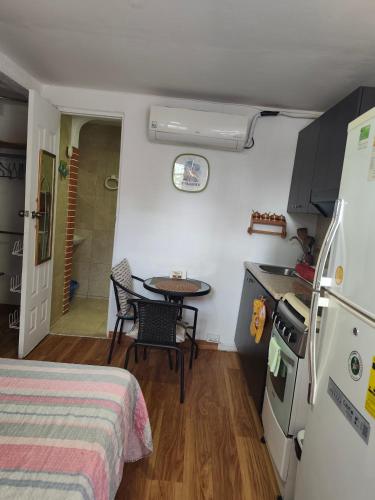 a small room with a table and a kitchen at Anexo independiente y privado totalmente amueblado muy lindo y acogedor en chanis cerca de Costa del este y el mall santa María plaza in Panama City