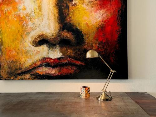 a desk with a lamp and a painting on a wall at La Marea in Cedar Grove