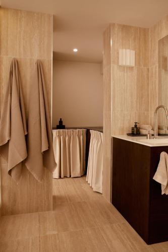 a bathroom with a sink and a row of towels at Noosa Parade Holiday Inn in Noosa Heads