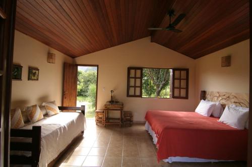 a bedroom with two beds and a window at Pousada Vale das Araras in Cavalcante