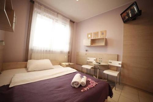 a bedroom with a bed with two towels on it at Standard Delegacyjny Bed & Breakfast in Dąbrowa Górnicza