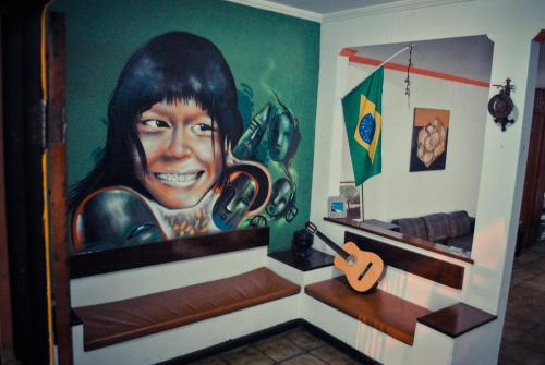 a painting of a woman with headphones on a wall at Cabo Frio Fun Hostel in Cabo Frio
