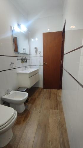 a bathroom with a toilet and a sink and a door at Salta Suite in Salta