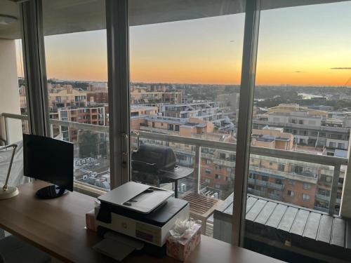 an office with a desk with a computer in front of a window at Darling Harbour Luxurious Retreat in Sydney