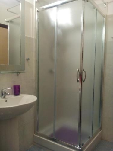 a shower with a glass door next to a sink at Apartment Napitia Hills in Pizzo