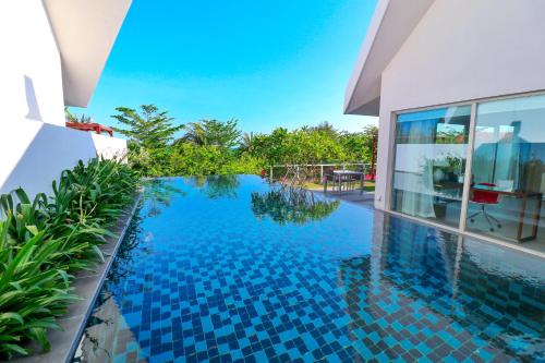 a swimming pool in front of a house at Palace Resort Villas Yalong Bay Sanya in Sanya