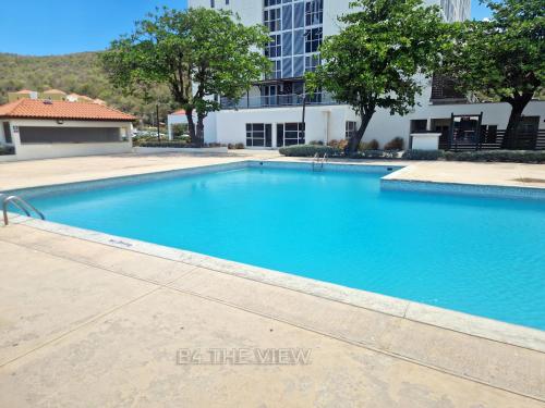 ein großer blauer Swimmingpool vor einem Gebäude in der Unterkunft B4 The View in Kupuis
