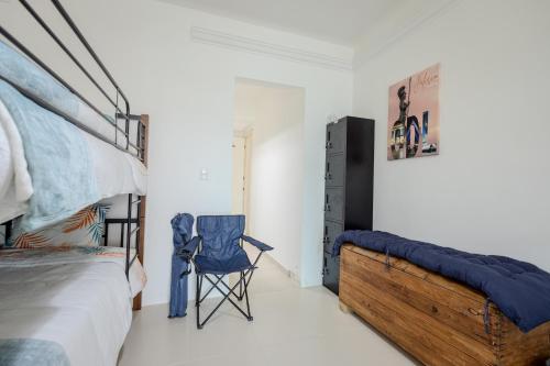 a bedroom with a bed and a blue chair at Habitación compartida en el Centro de Cancún in Cancún