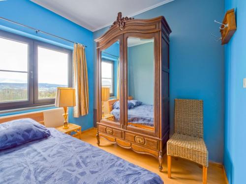 a bedroom with a large mirror and a chair at Holiday Home in Lierneux with Private Garden in Lierneux