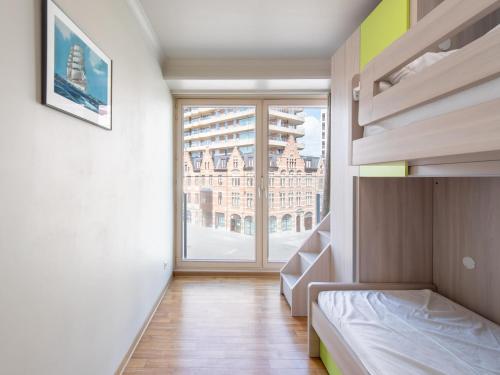 a bedroom with a bed and a large window at Apartment in Ostend with Marina Views in Ostend