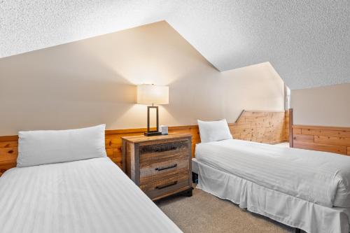 ブリッケンリッジにあるRockridge 47 by Summit County Mountain Retreatsのベッドルーム1室(ベッド2台、ナイトスタンドのランプ付)